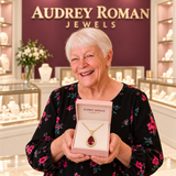 Julia Red Teardrop Pendant Necklace (gold-tone) presented in its rose box by the woman in the Audrey boutique.