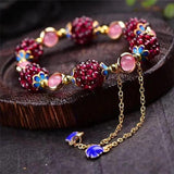 Ruth Red Bead Charm Bracelet with pink oval centers, blue floral details and dangling chains